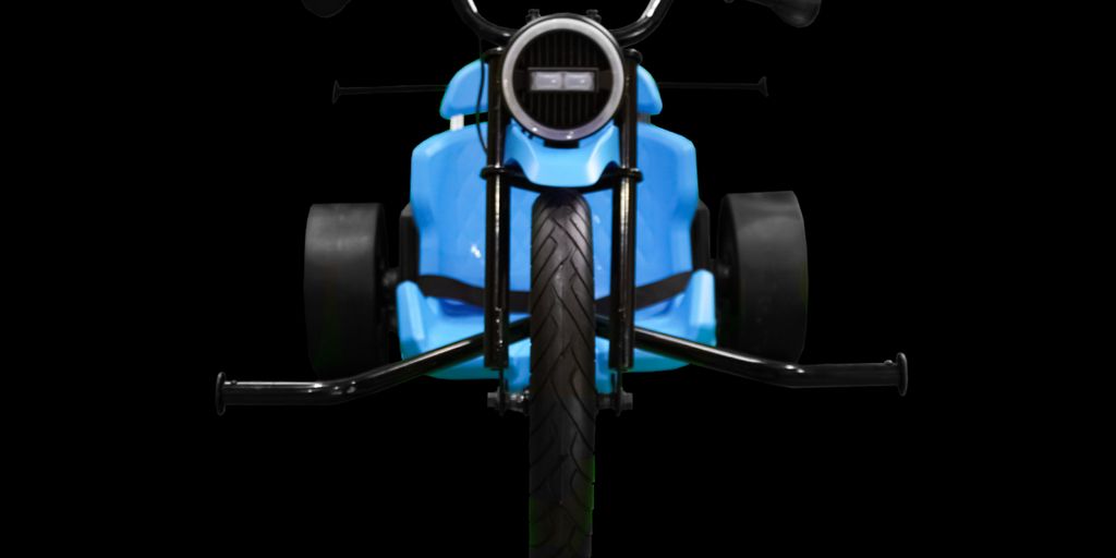 Blue three-wheeled bike with a sleek design and large tires.