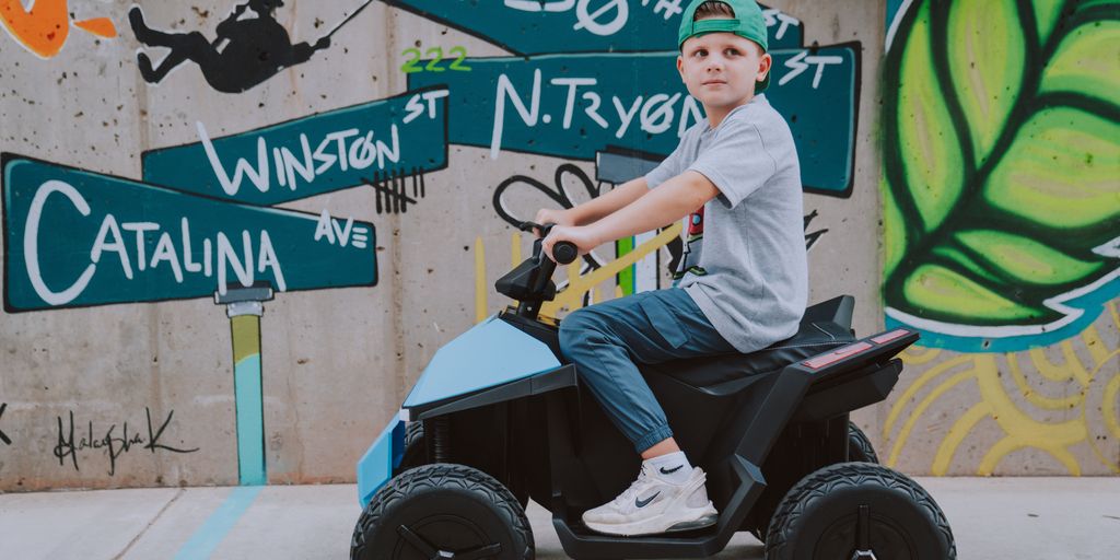 Child riding a toy vehicle in a colorful urban setting.