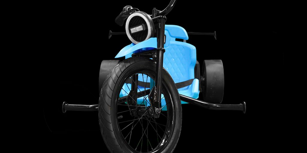A blue, futuristic tricycle with large black wheels.